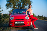 Фото красного автомобиля Chery Sweet QQ с девушкой рядом на фоне природы