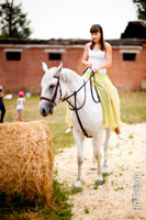 Фото девушки верхом на белой лошади, лошадь ест сено