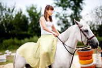 Девушка ездит на лошади верхом по кругу