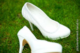 Фото белых свадебных туфель невесты на зеленой траве