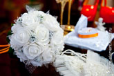 Фото букета невесты из белых роз и различных свадебных аксессуаров невесты на столе