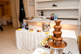 Фото шоколадной пирамиды на столе, вдали - шампанское и бокалы