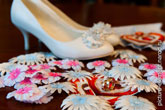 Фото золотых обручальных колец и туфель невесты вдали