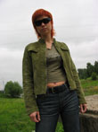 Поясное фото девушки в зеленом пиджаке и в солнечных очках